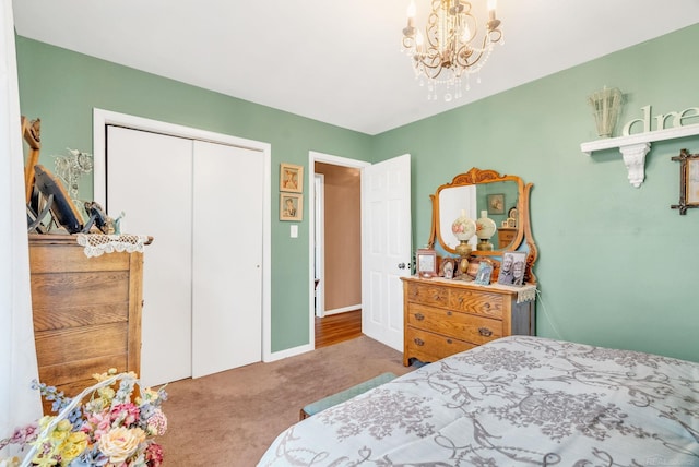 carpeted bedroom featuring a closet and a chandelier