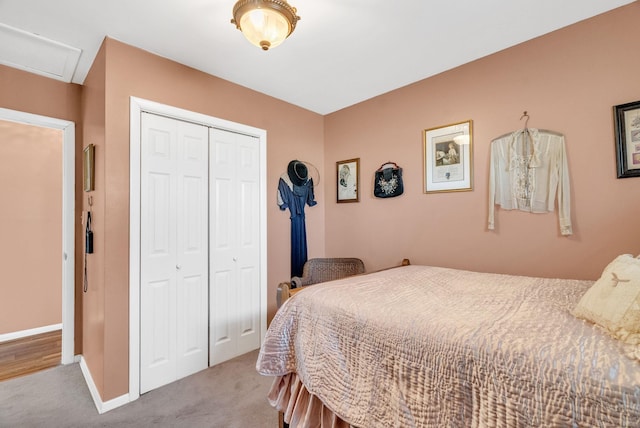 carpeted bedroom with attic access, baseboards, and a closet