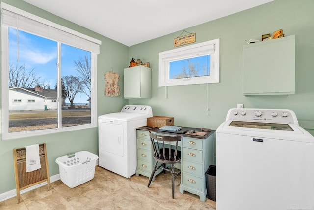 laundry area featuring baseboards, cabinet space, and washing machine and clothes dryer