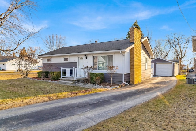 view of front of property featuring central AC unit, a chimney, a garage, an outdoor structure, and driveway