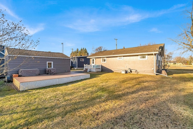 rear view of house featuring a yard and a deck