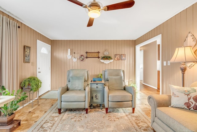 living area with a ceiling fan and baseboards