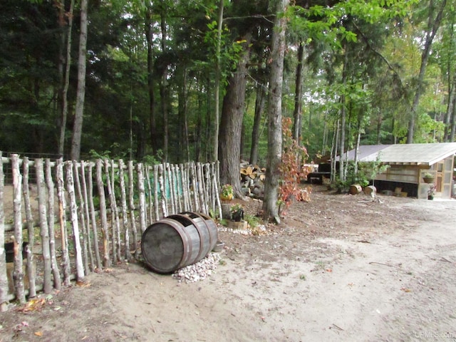 view of yard with a wooded view and fence