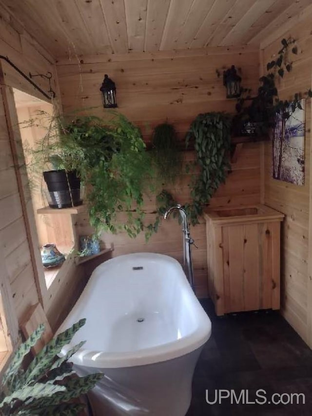 bathroom with a soaking tub, wood ceiling, and wood walls