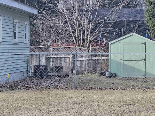 view of yard featuring an outdoor structure, fence, and a shed