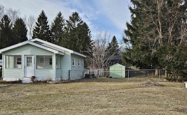 view of front facade featuring a storage unit, an outdoor structure, a front lawn, and fence