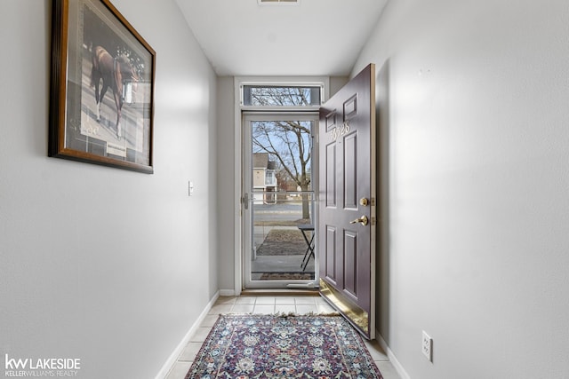 doorway featuring light tile patterned floors, visible vents, and baseboards