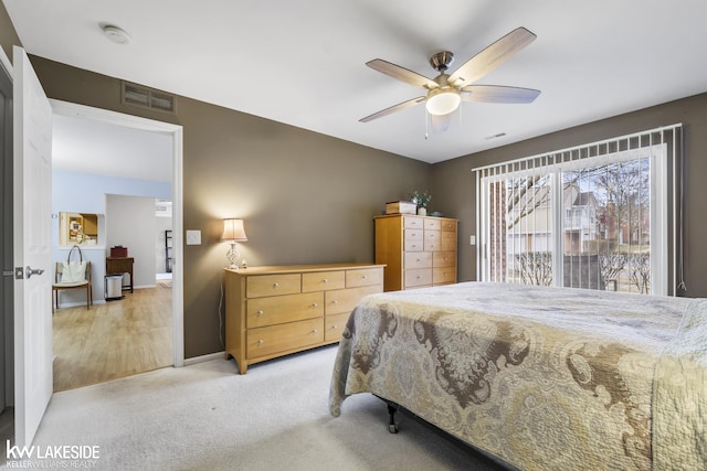 bedroom featuring visible vents, light colored carpet, baseboards, and ceiling fan