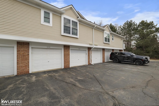 view of side of property with brick siding and community garages