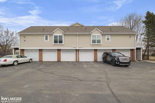 view of home's exterior featuring a garage, brick siding, and driveway