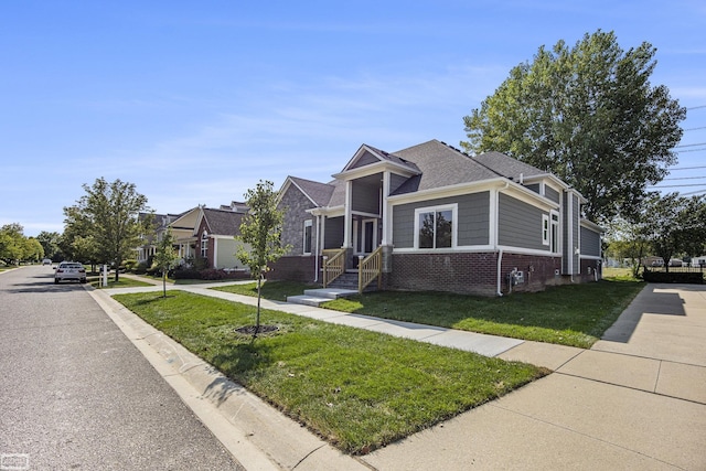 bungalow-style house featuring brick siding, roof with shingles, and a front lawn