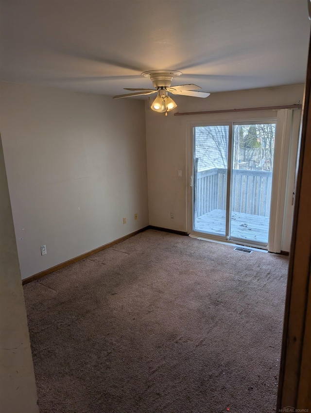 carpeted empty room with visible vents, baseboards, and ceiling fan