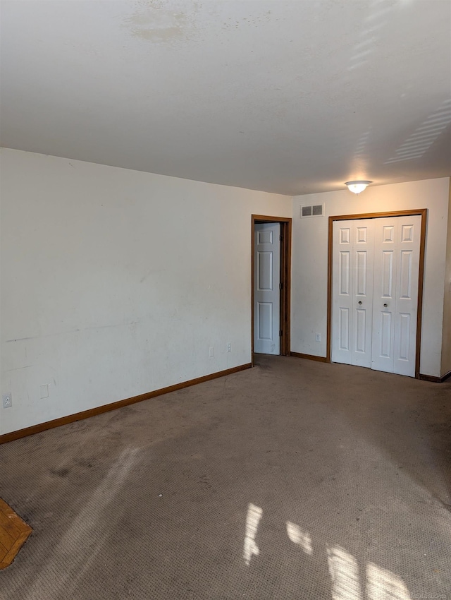 unfurnished bedroom with visible vents, baseboards, and carpet