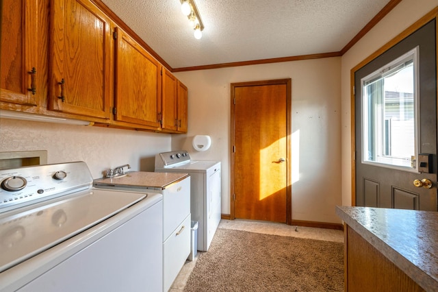 washroom featuring crown molding, washer and clothes dryer, cabinet space, and a textured ceiling