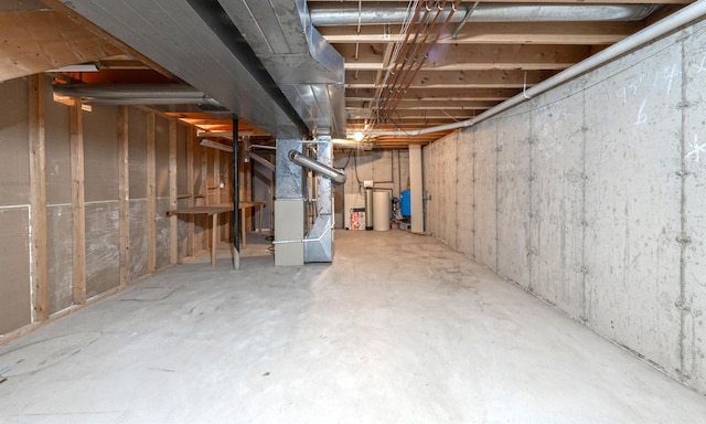 unfinished basement featuring gas water heater and heating unit