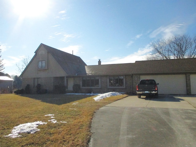 view of front of home featuring driveway, an attached garage, and a front lawn