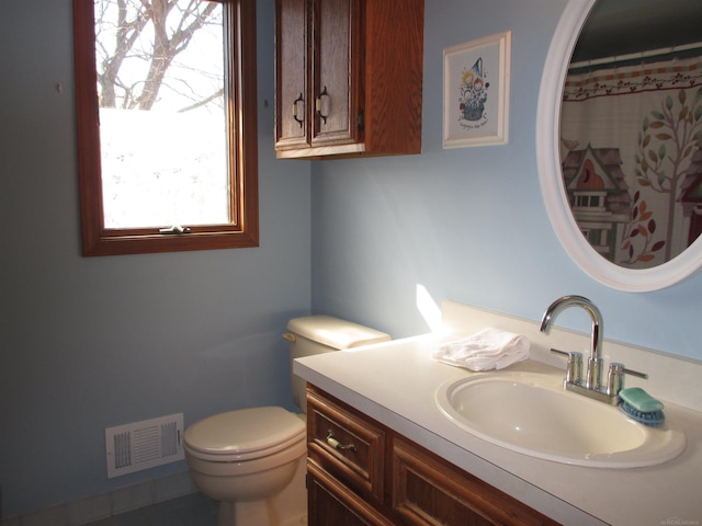 bathroom featuring vanity, toilet, and visible vents