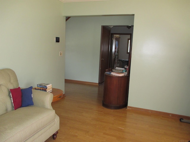 sitting room with baseboards and light wood-style floors