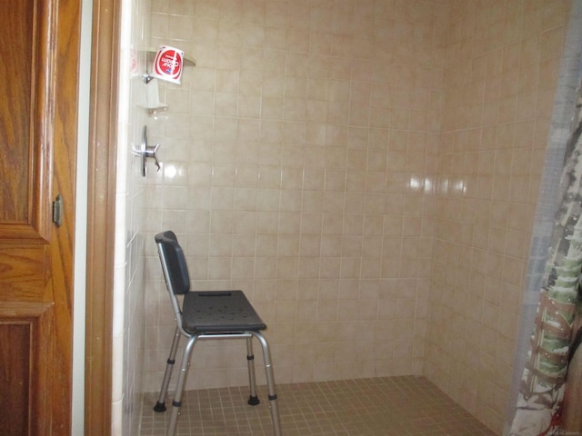 bathroom featuring tiled shower and tile walls