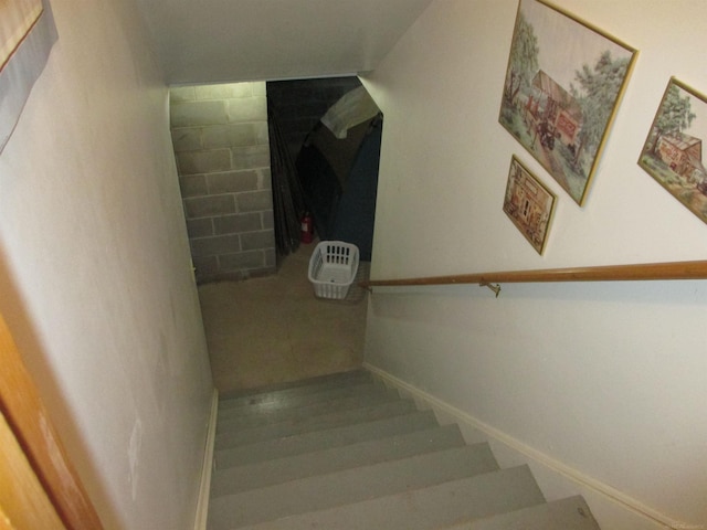 staircase featuring baseboards and wood finished floors