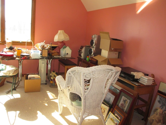 carpeted dining room with vaulted ceiling