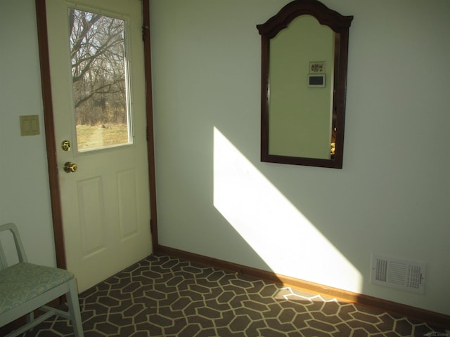 doorway to outside with visible vents, plenty of natural light, and baseboards