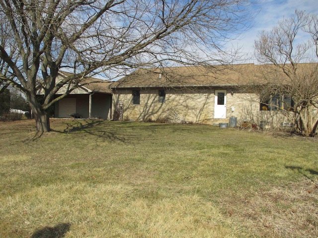 rear view of house with central air condition unit and a yard