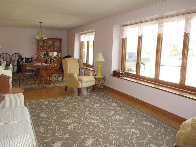 living area with plenty of natural light, baseboards, and wood finished floors