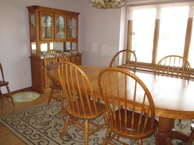 dining room with a wealth of natural light, baseboards, and a notable chandelier