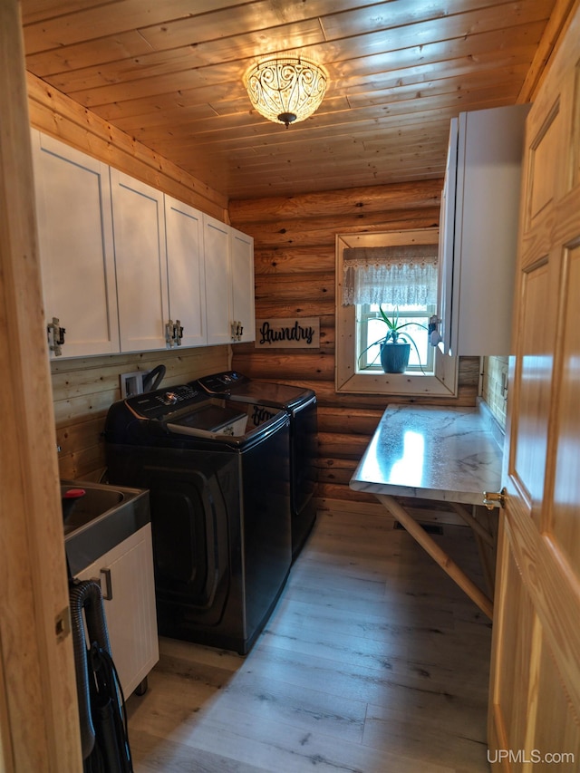 laundry area with independent washer and dryer, cabinet space, light wood finished floors, log walls, and wood ceiling