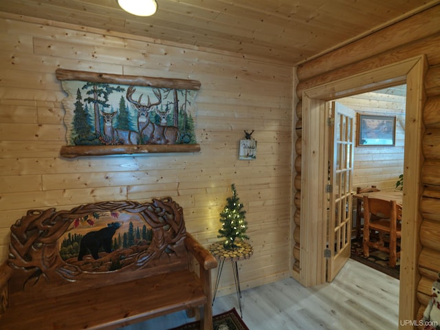 dining space featuring rustic walls, light wood-style floors, and wood ceiling