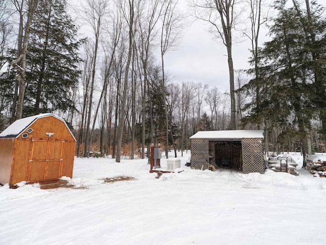 snowy yard featuring an outdoor structure and ac unit