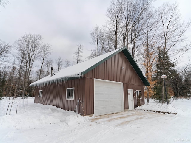 snow covered garage with a detached garage