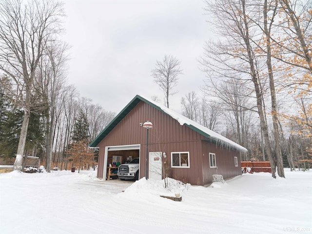 snow covered garage featuring a garage