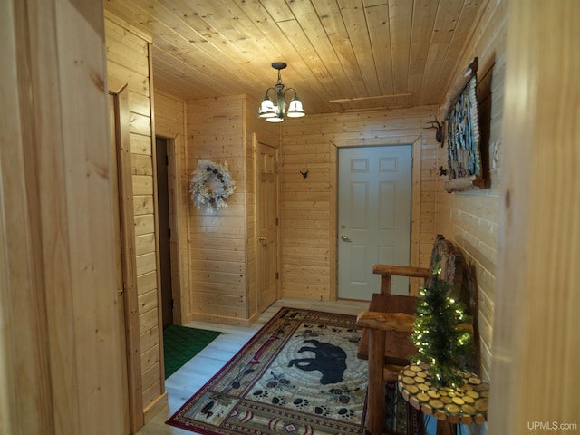 interior space featuring a chandelier, wood walls, and wooden ceiling