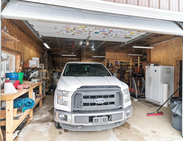 garage with freestanding refrigerator and a garage door opener