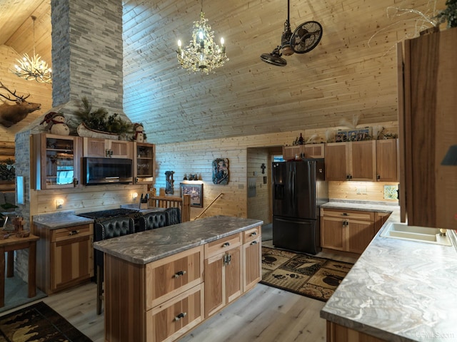 kitchen featuring a sink, high vaulted ceiling, light wood-style floors, and black refrigerator with ice dispenser