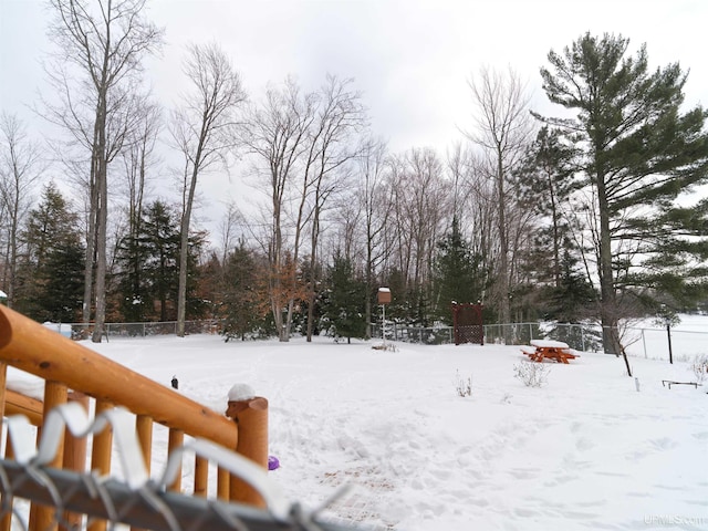 yard covered in snow featuring fence