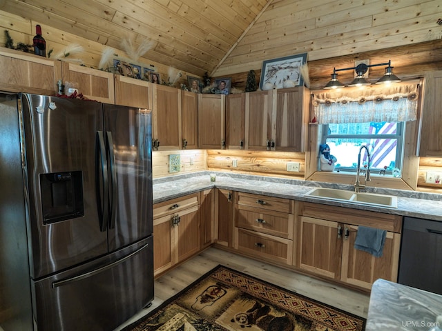 kitchen featuring lofted ceiling, a sink, stainless steel fridge, black dishwasher, and light wood-type flooring