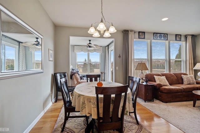 dining area with recessed lighting, light wood-style flooring, ceiling fan with notable chandelier, and baseboards