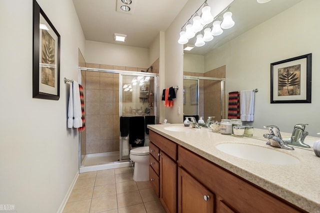 bathroom with a shower stall, toilet, double vanity, tile patterned floors, and a sink