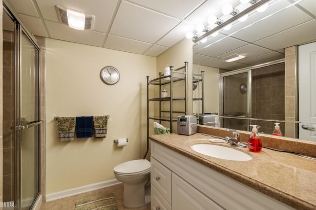 bathroom with a tile shower, visible vents, and a drop ceiling