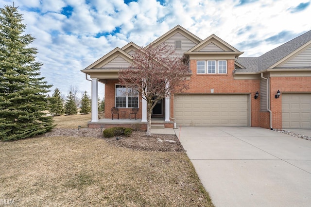 traditional-style home with a porch, a garage, brick siding, and driveway