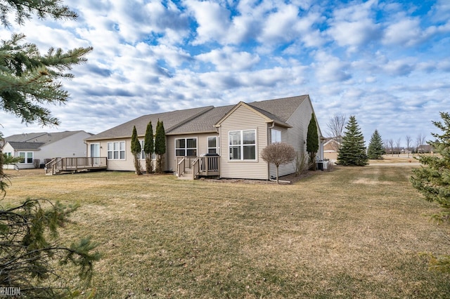 back of property with a lawn and a deck