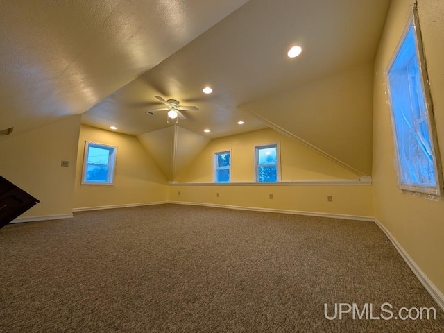 additional living space featuring dark colored carpet, baseboards, recessed lighting, and vaulted ceiling