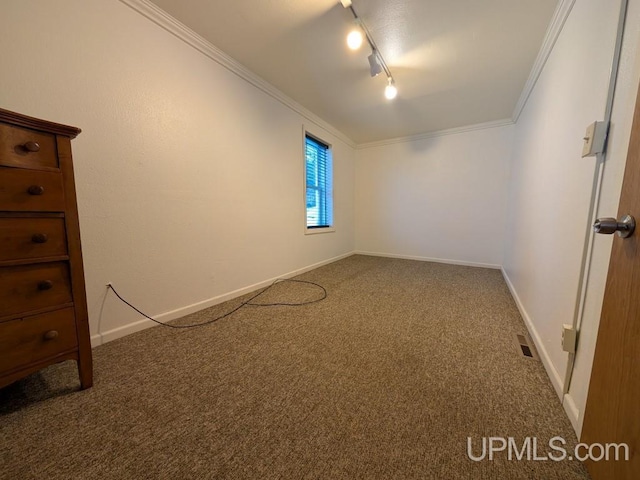 carpeted empty room with track lighting, baseboards, visible vents, and ornamental molding