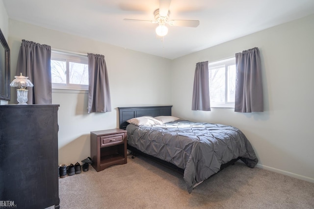 bedroom featuring multiple windows, light carpet, baseboards, and ceiling fan