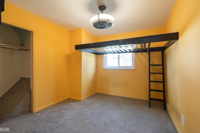 unfurnished bedroom featuring carpet flooring, baseboards, and a closet