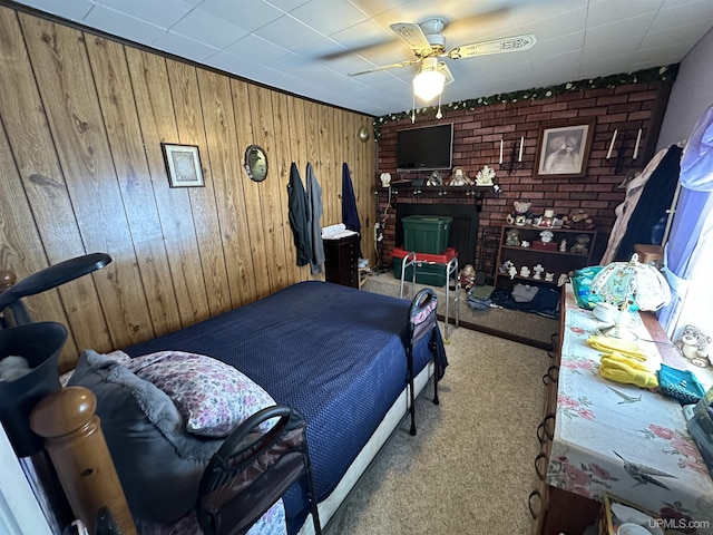 bedroom featuring wood walls, a ceiling fan, and carpet