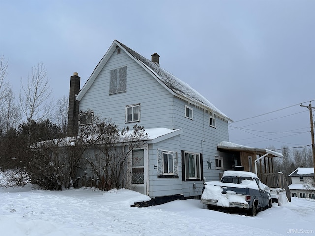 snow covered property featuring a chimney